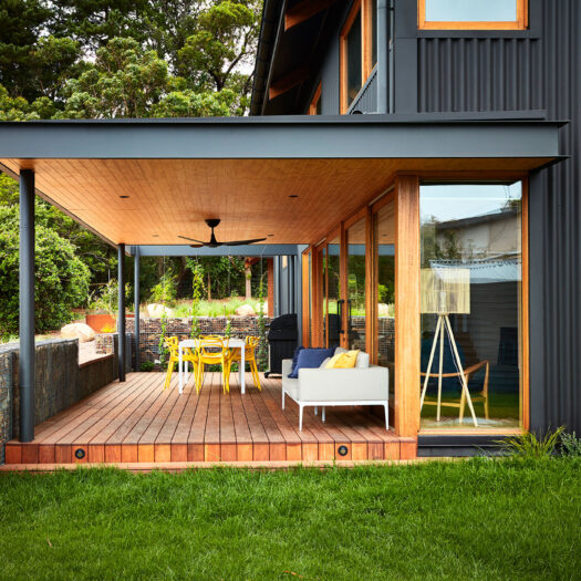 Main Ridge Barn outdoor dining space on verandah with yellow furniture - building photographer example / concept