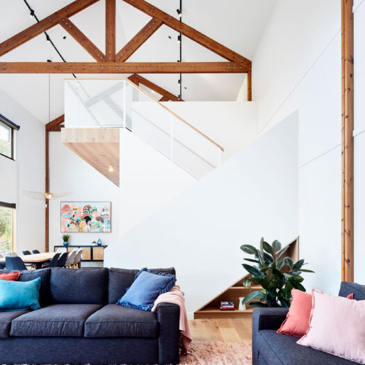 Main Ridge Barn view across sofa to staircase with timber beams above - building photographer example / concept
