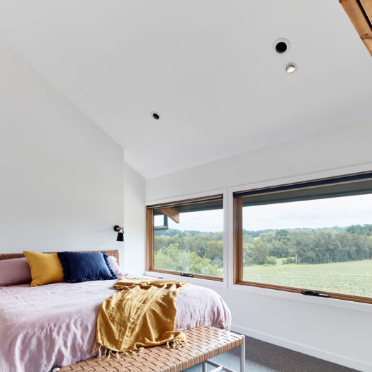 Main Ridge Barn master bedroom with pastel bedding and view to strawberry fields - building photographer example / concept