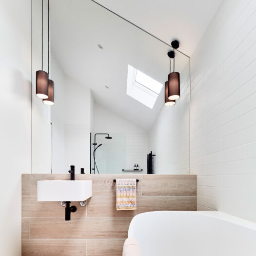 Main Ridge Barn bathroom vanity with timber look tiles across bath and with two pendant lights - building photographer example / concept