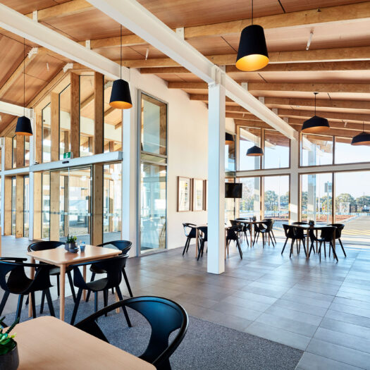 TLC Aged Care Homestead Estate cafe style seating with timber ceiling, white steel beams and view to outside - building photographer example / concept