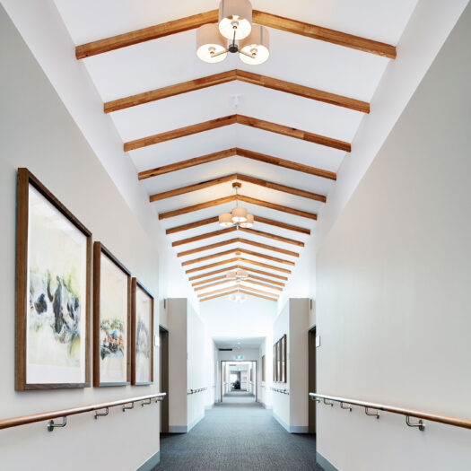TLC Aged Care Homestead Estate hallway with handrails, high ceiling and timber features - building photographer example / concept