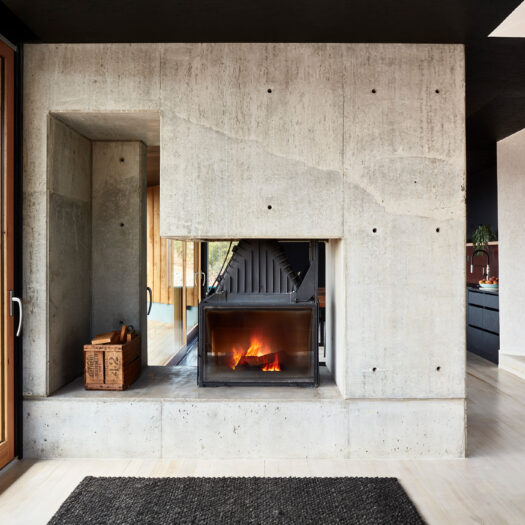 concrete fireplace with roaring fire - building photographer example / concept