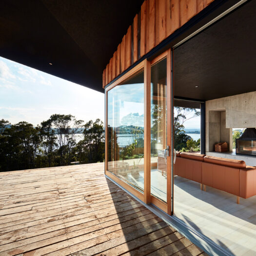 timber deck with streaming sunlight and view to river - building photographer example / concept