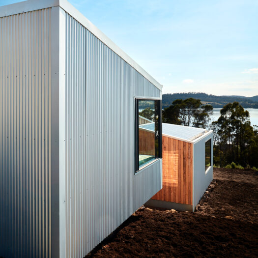 house on sloping block looking down to Tamar River, Tasmania - building photographer example / concept