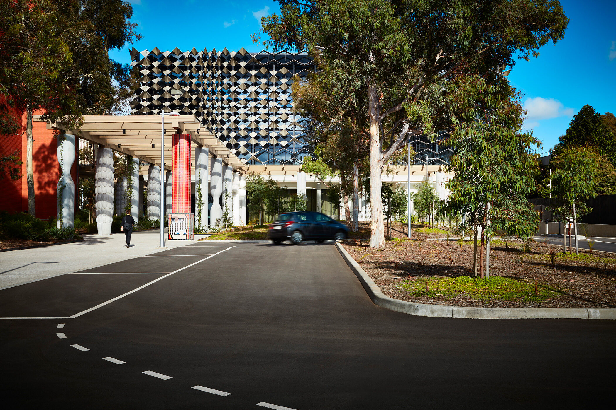 Monash University Chancellery front on view of vehicle entry side of building with red mosaic artist column - University example / concept