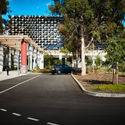 Monash University Chancellery front on view of vehicle entry side of building with red mosaic artist column - University example / concept