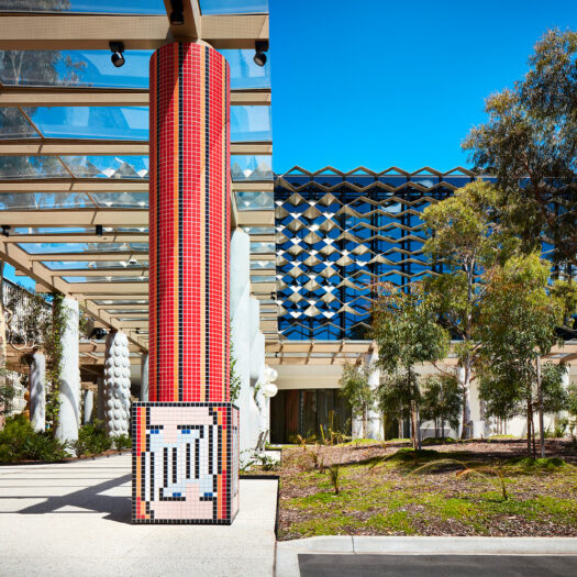 Monash University Chancellery red tile mosaic artist column with building in background - University example / concept