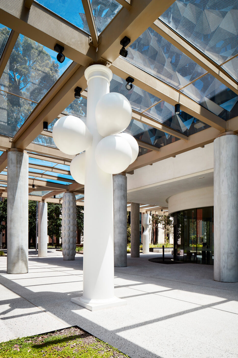 Monash University Chancellery white bubble artist column looking through other columns to campus - University example / concept