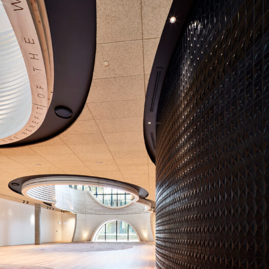 Monash University Chancellery black tiled wall looking into natural tones of atrium space - University example / concept