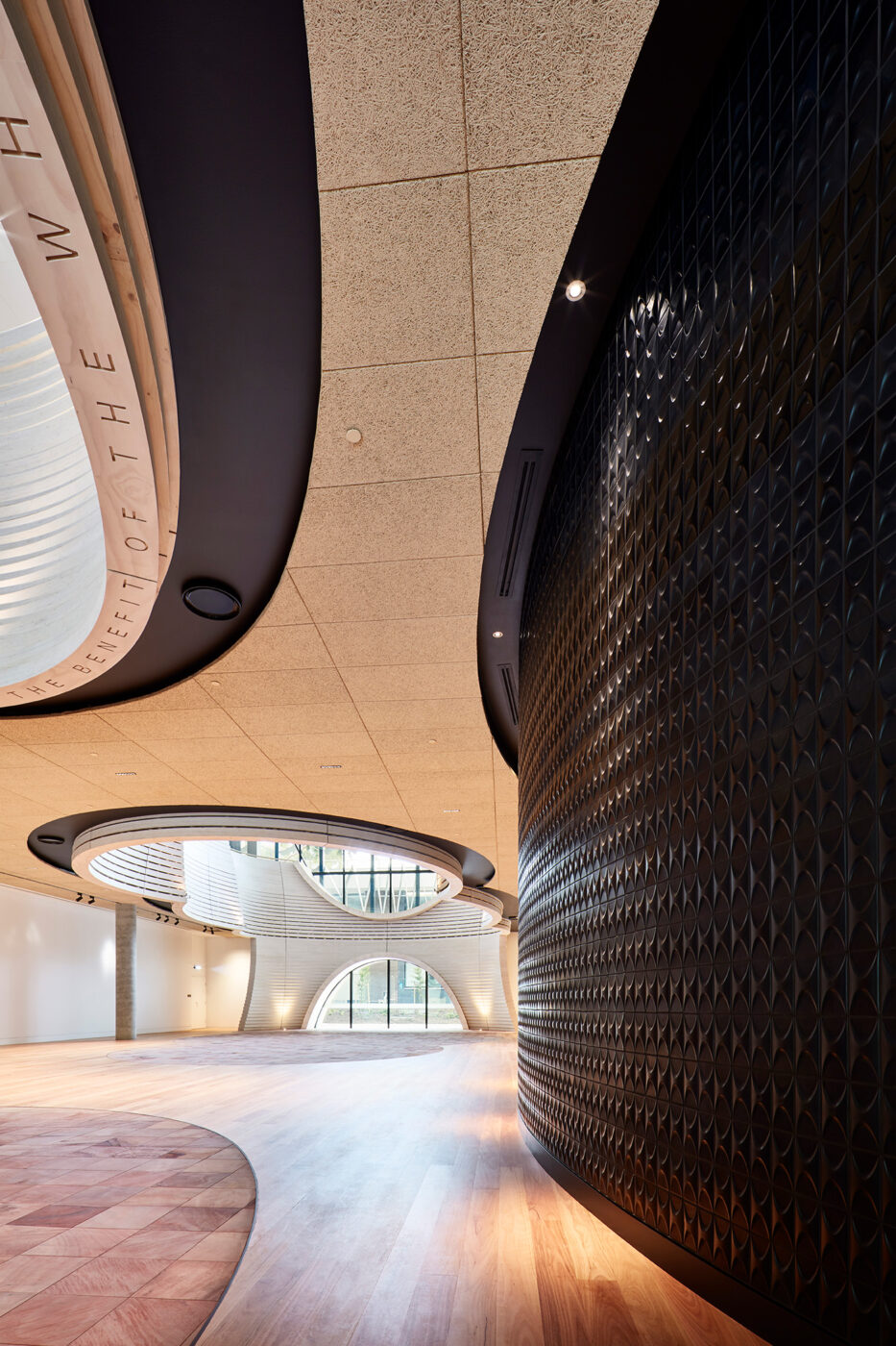 Monash University Chancellery black tiled wall looking into natural tones of atrium space - University example / concept