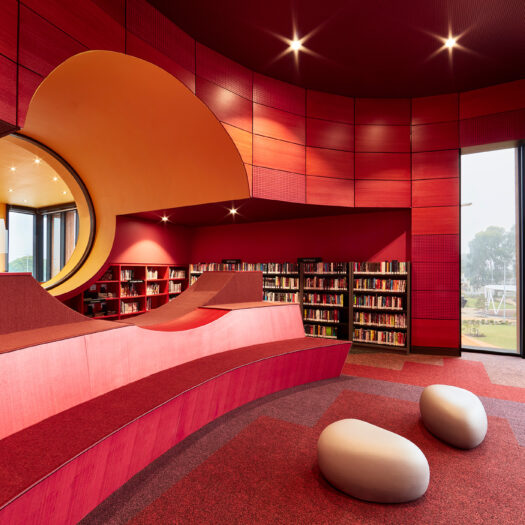 Springvale Library and Community Hub red interior with yellow round window with books on shelves - structure photographer example / concept
